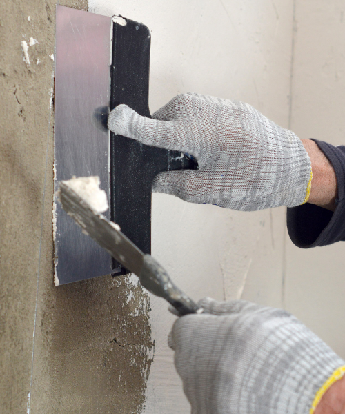 A person using a drill to fix a wall